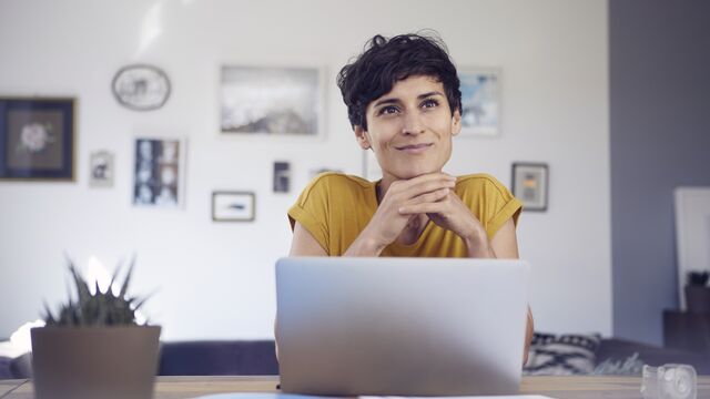 Smiling woman using laptop at home